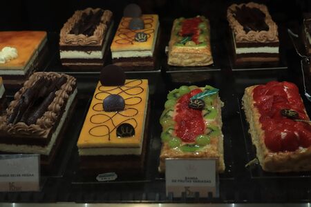 Barcelona, Spain - september 30th 2019: Luxurious confectionery on display in a luxurious supermarket. Text on tags: product information in Spanish. Flan, chocolate and raspberryのeditorial素材