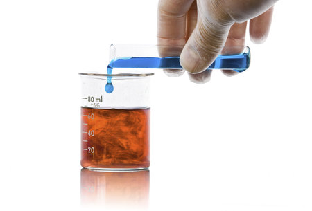 hand pouring liquid chemicals into flask