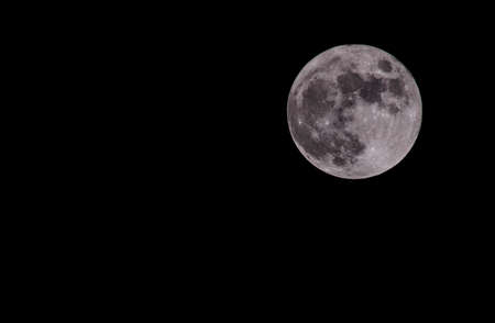 Full moon isolated on a black skyの写真素材