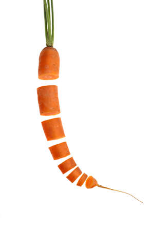 fresh carrot sliced in many pieces, isolated over whiteの写真素材