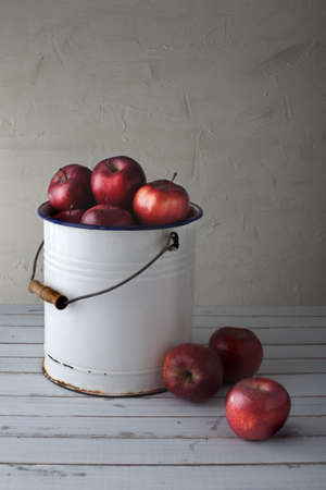 red apples in an old iron bucket, focus is on the lower right appleの写真素材