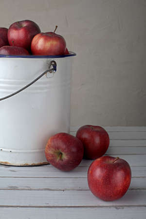 red apples in an old iron bucket, focus is on the lower right appleの写真素材