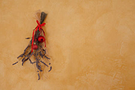 bunch of lavender flowers hung on an jellow spatula wall, as a christmas decorationの写真素材