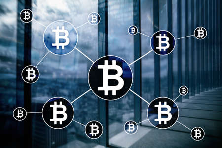 Bitcoin cryptocurrency and blockchain technology concept on blurred skyscrapers background.の写真素材
