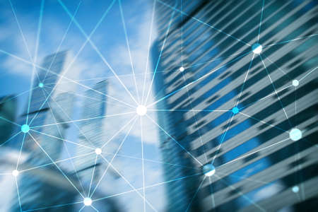 Blockchain network on blurred skyscrapers background. Financial technology and communication concept.の写真素材