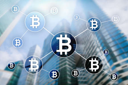Bitcoin cryptocurrency and blockchain technology concept on blurred skyscrapers background.の写真素材