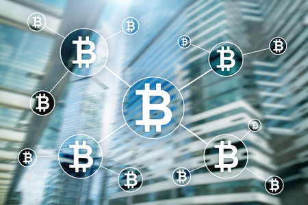 Bitcoin cryptocurrency and blockchain technology concept on blurred skyscrapers background.
