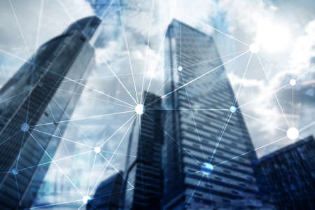 Blockchain network on blurred skyscrapers background. Financial technology and communication concept.の写真素材