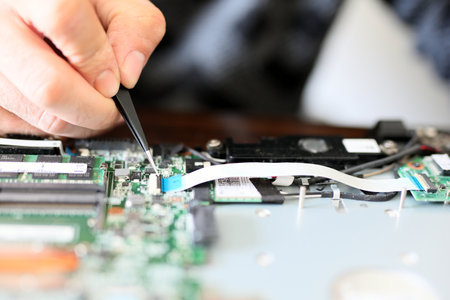 Expert is repairing to inner of laptop with screwdriver. The design restrictions on power, size, and cooling of laptops limit the maximum performance of laptop parts compared.の写真素材