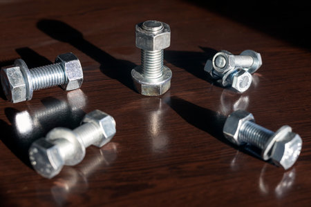 Metal bolts and nuts on a dark wooden background. close-up.