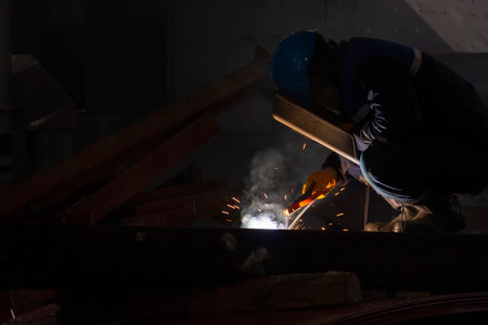 Welder is welding with shielded metal arc welding, manual metal arc welding or stick welding. Electric current is used to strike an arc between base material, consumable electrodeの写真素材