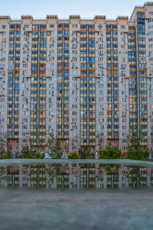 Reflection trees, building in the puddle on the table tennis on the playground. Vertical. Copy space for textの写真素材