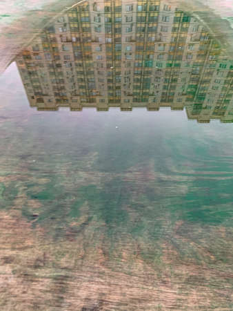 Reflection blu sky, clouds, building in the puddle on the table tennis on the playground. Mobilephoto. Vertical. Copy space for textの写真素材