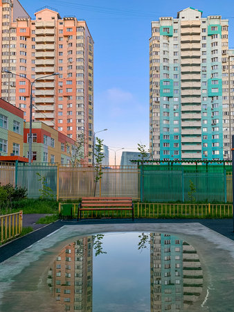 Reflection blu sky, trees, clouds, building in the puddle on the table tennis on the playground. Mobilephoto. Vertical. Copy space for textの写真素材