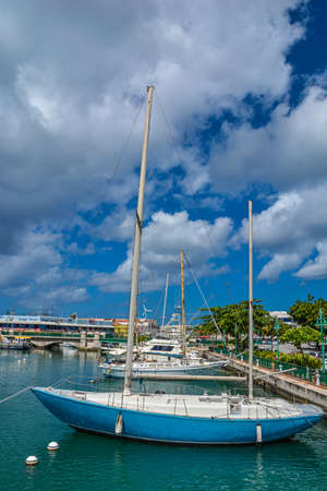 Bridgetown, Barbados - 22 Sept 2018: Sailing yachts moored in the downtown marina bay of Bridgetown, Barbados, Caribbean. White clouds in the blue sky. Copy space. Verticalのeditorial素材
