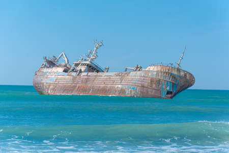 Laayoune port, Morocco, Western Sahara - January 6, 2019: a rusty shipwreck lies on its side under the blue sky in the Atlantic Ocean. Copy spaceのeditorial素材