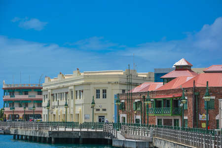Bridgetown, Barbados Caribbean - 22 Sept 2018: Wooden boardwalk at the Careenage in the marina at Bridgetown. White clouds in the blue sky. Copy spaceのeditorial素材