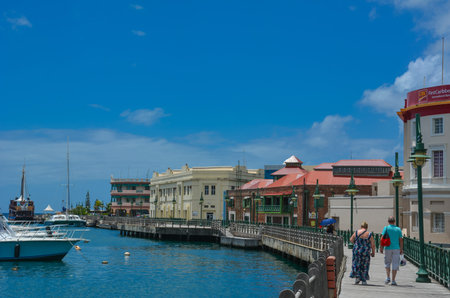 Bridgetown, Barbados, Caribbean - 22 Sept 2018: Couple walking along the promenade at marina bay of Bridgetown, Barbados. Copy spaceのeditorial素材