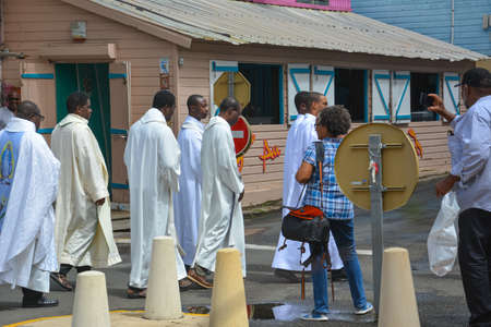 Sainte Anne, Martinique - Sept 19, 2018: Catholic preachers in church robes walk down the street during a festive procession in Martiniqueのeditorial素材