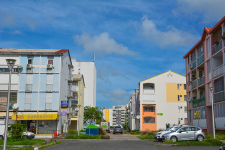 Point-a-Pitre, Guadeloupe - Sept 17, 2018: Street with colorful modern apartment buildings, a shop and parked cars in Guadeloupe. Copy spaceのeditorial素材