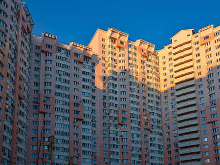 Krasnogorsk, Moscow region, Russia - May 17, 2020: Residential facade of a high-rise building with many windows and balconies in the blue sky. Copy space for textのeditorial素材