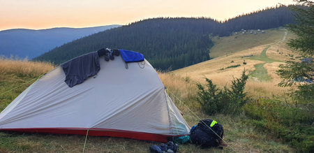 Camping tent on a mountain meadow, scenic landscape in the Carpathians, outdoor adventure, travel.