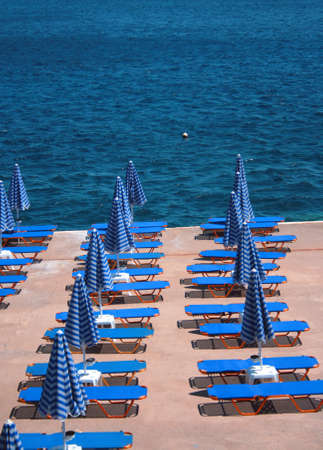 Chairs and umbrellas next to the sea.の写真素材