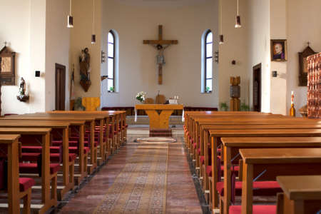 Inside of a large, traditional catholic church with pews and cross visible.のeditorial素材