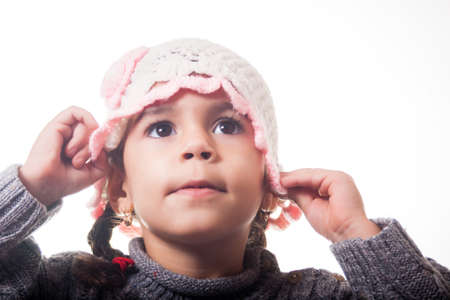 Girl arranging her knitted hat, on white background の写真素材