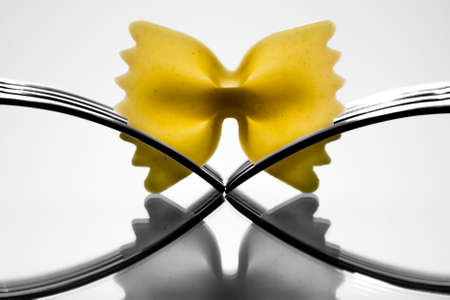 Farfalle pasta held by two forks の写真素材