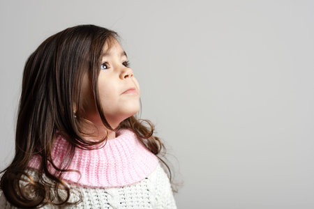 Adorable little girl with long hair looking up