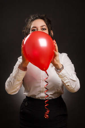 happy stylish woman playing with red balloonの写真素材