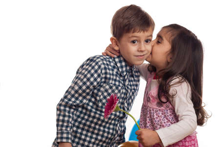 girl giving kiss to boy on white backgroundの写真素材