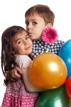 boy giving kiss to girl with flowers and balloons on white backgroundの写真素材