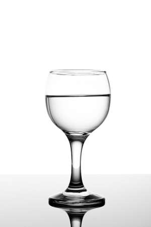 Classy backlit glass of water on white backround and reflectionの写真素材