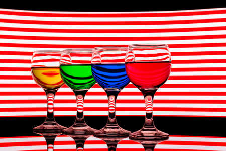 red, green, yellow and blue backlit drinks with reflectionの写真素材