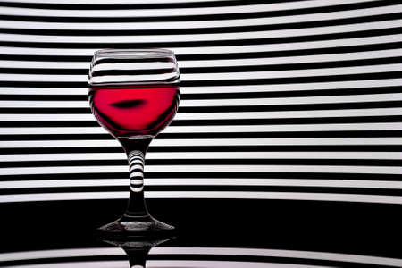 Classy colrfull backlit red vine glass with reflectionの写真素材