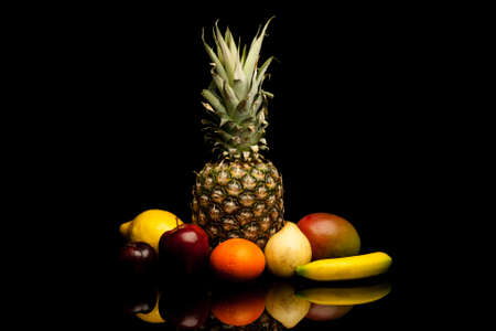 bunch of exotic fruits on black background with reflectionの写真素材