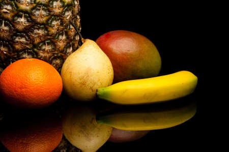 bunch of exotic fruits on black background with reflectionの写真素材