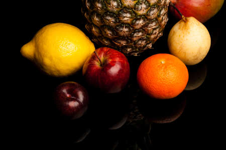 bunch of exotic fruits on black background with reflectionの写真素材