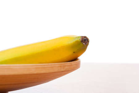 fresh yellow banana on brown wooden plateの写真素材