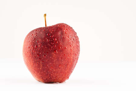 Fresh red apple whit waterdrops on white backgroundの写真素材