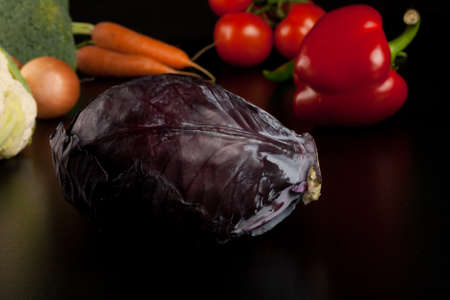 red cabbage on black with different vegetables in the backgroundの写真素材