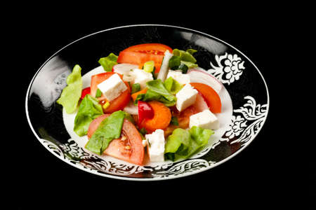 vegetable salad in stylish balck and white plate on black backgroundの写真素材