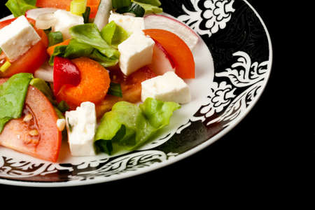 vegetable salad in stylish balck and white plate on black backgroundの写真素材