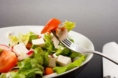 vegetable salad close up on a fork with dark backgroundの写真素材