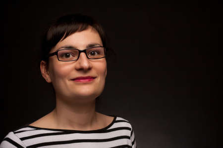 portrait of a stylish expressive woman with glasses in studioの写真素材