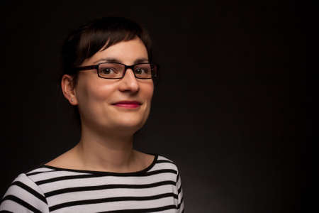 portrait of a stylish expressive woman with glasses in studioの写真素材