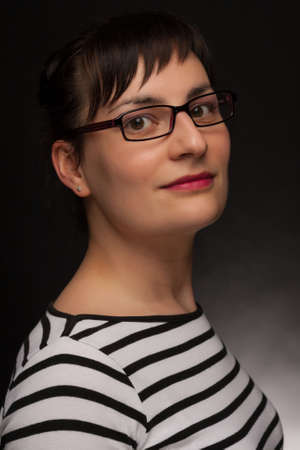 portrait of a stylish expressive woman with glasses in studioの写真素材