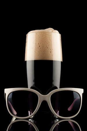 glass of black beer with white sunglassの写真素材